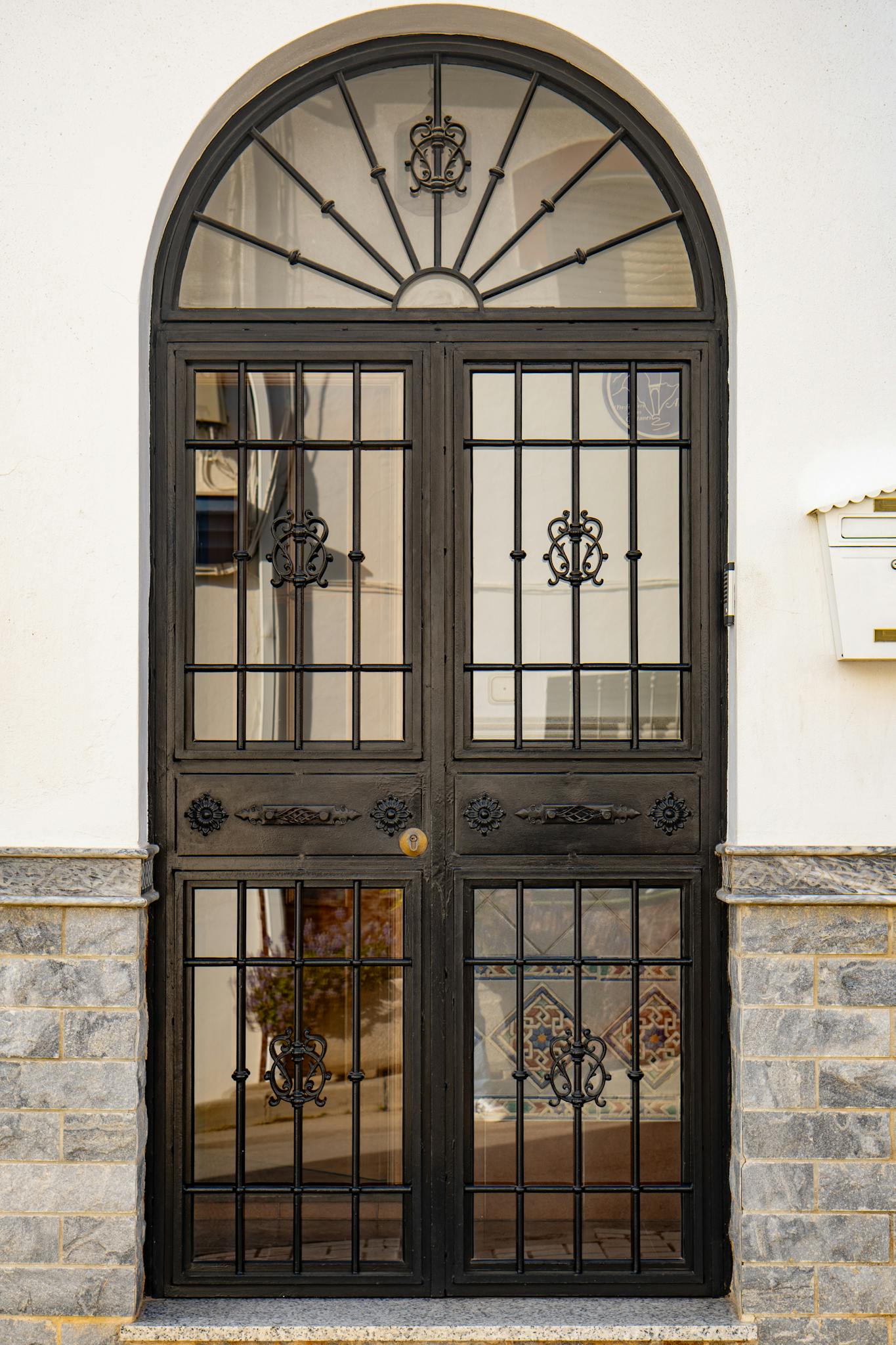 Stylish black iron door with intricate metalwork in Spain.